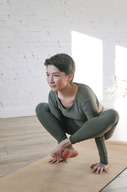 A calm woman meditates in a peaceful yoga pose inside a brightly lit room
