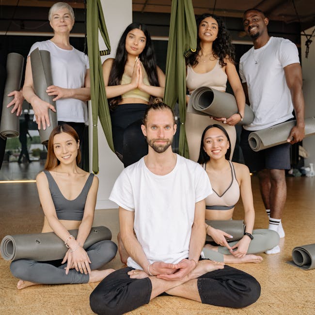 A smiling group of diverse people on yoga mats after a class in a modern studio